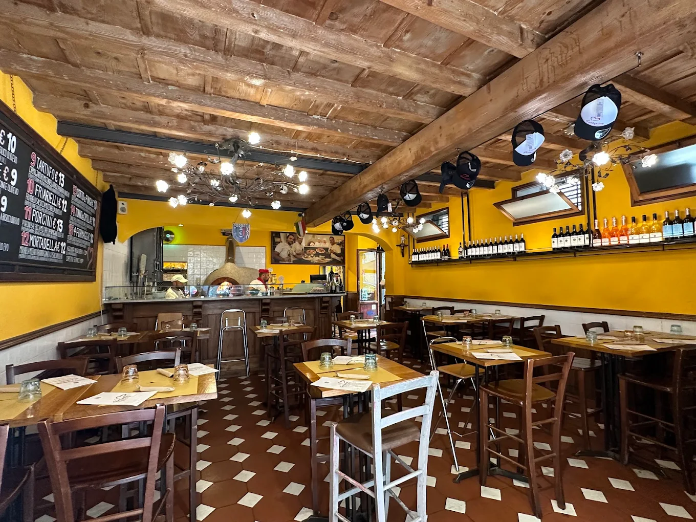 La sala di GustaPizza con soffitto in legno e forno a legna
