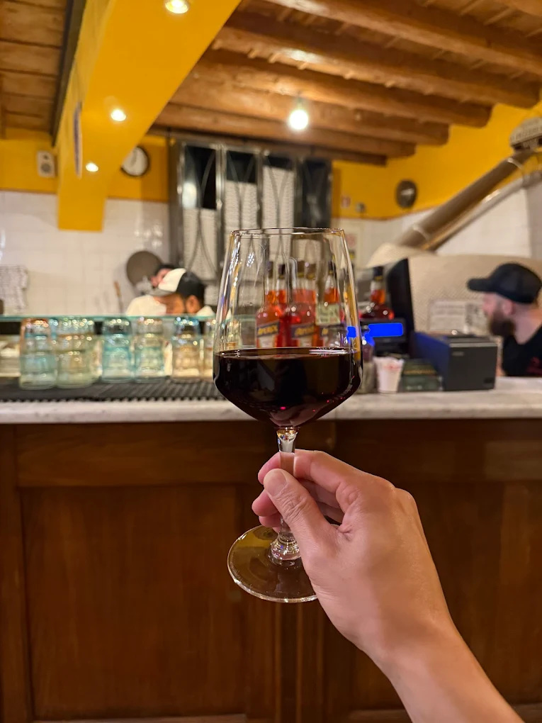 Un calice di vino della casa al bancone